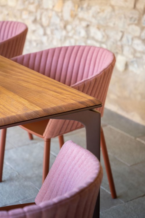 Holztischecke mit rosa gepolsterten Stühlen mit runden Rückenlehnen darum herum.