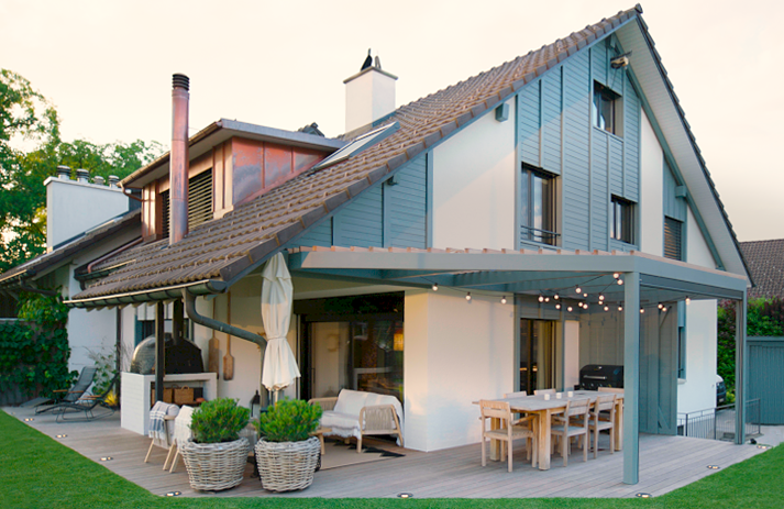 Einfamilienhaus mit grauer Holzfassade, Terrasse und Rasen