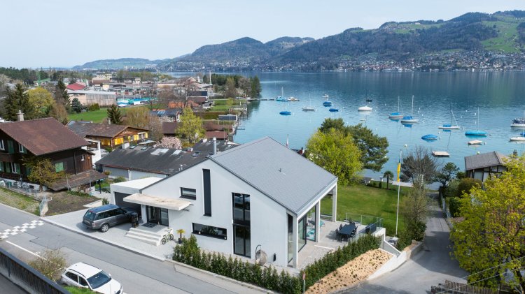 Luftaufnahme von modernem Haus mit Satteldach nahe See