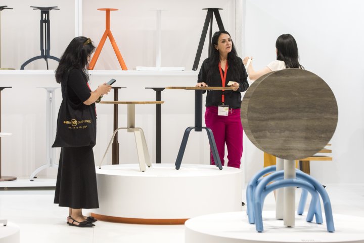 drei Personen an weissem Messestand mit Kleinmöbeln