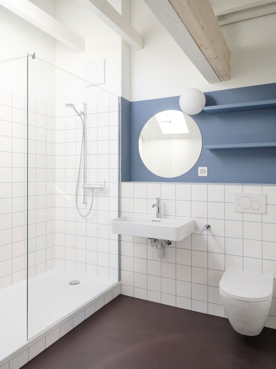 Bad mit dunkelrotem Boden, weissen Platten und taubenblauer Wand mit Spiegel