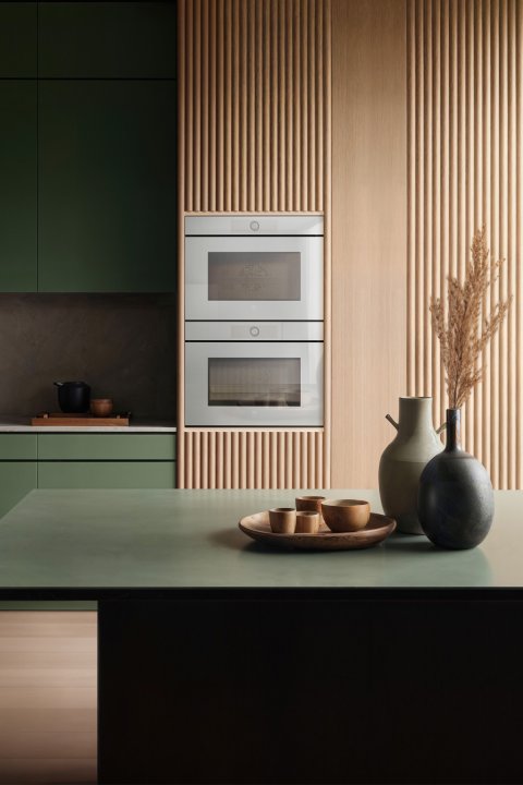 Foto von moderner dunkelgrüner Küche mit minimalistischen Geräten und Keramikvasen auf der Ablagaefläche