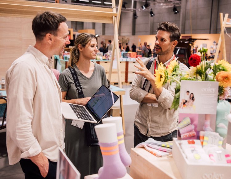 Besuchende an einem Verkaufsstand mit Socken