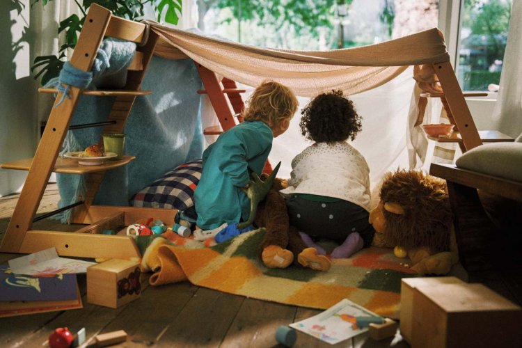 Kinder spielen in Zelt aus Stofftüchern