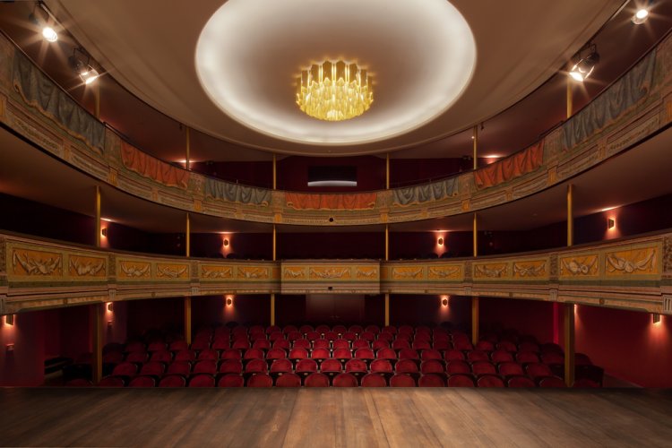 Stadtheater Solothurn: Blick von der Bühne in den Saal mit geschwungenen Galerien und roter Bestuhlung im Parterre.