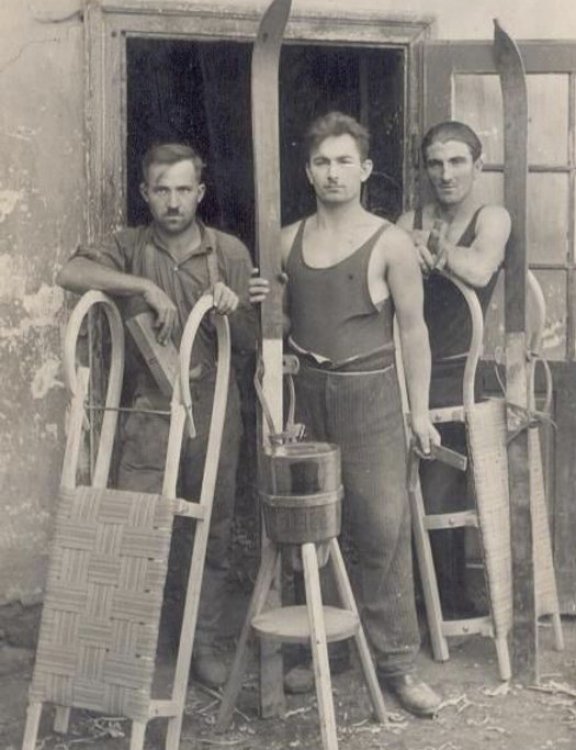 Drei Arbeiter mit Schlitten vor Fabrik, historische Aufnahme in schwarz-weiss