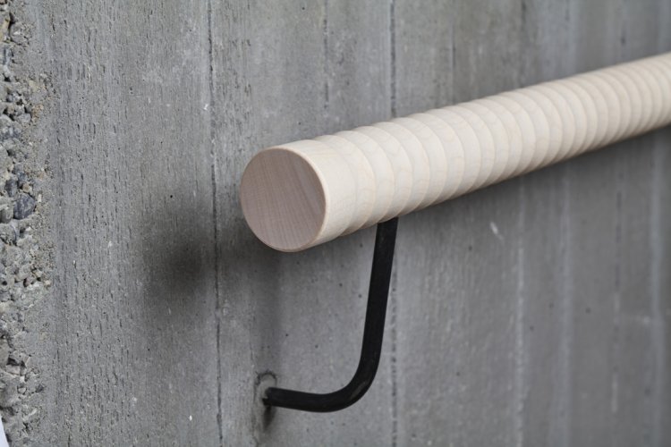 Handlauf aus Holz an einer Betonwand angebracht