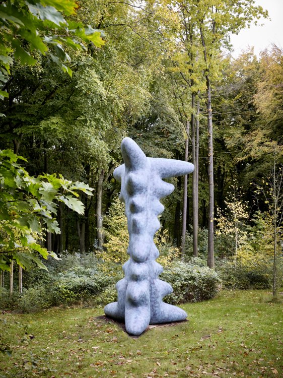 Eine Steinskulptur mit Zacken auf einer Waldlichtung