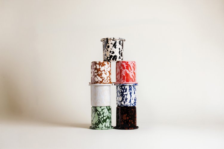 Ein Stapel aus sieben verschiedenen, bunt gesprenkelten ÉMAÉ-Mini-Mugs. Die Becher sind in einer Pyramidenform vor einem neutralen, hellen Hintergrund arrangiert und zeigen die gesamte Farbpalette der Mirari Collection: von kräftigem Blau und Rot über erdiges Braun und Schwarz bis hin zu sanftem Grün und Beige. Minimalistisches Studio-Produktfoto.