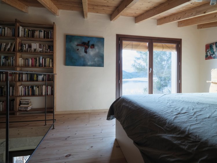 Schlafzimmer von Stone and Water mit Blick durch eine große Öffnung auf den Guadiana.