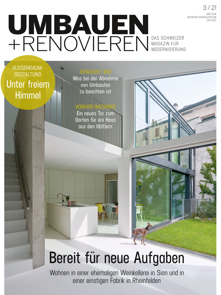 Titelbild der Zeitschrift Umbauen+Renovieren, das aus einem überhohen Wohnraum in einen Garten hinein fotografiert ist.
