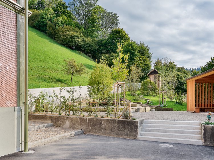 Garten eines Schulhauses mit einer alten und einer neuen Laube