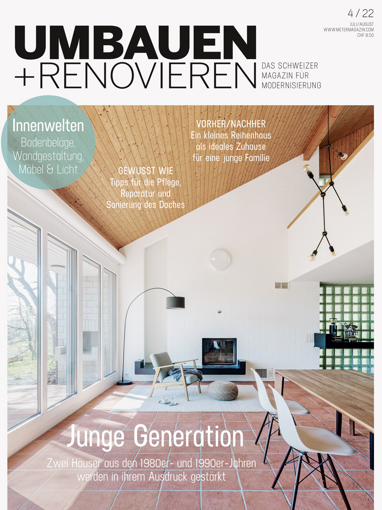 Titel der Zeitschrift Umbauen+Renovieren mit einem Bild, das einen überhohen Raum mit einer Holzdecke und Bodenplatten aus Ton, ein Kamin und Stühle an einem Esstisch zeigt