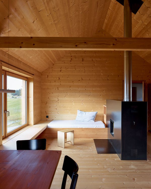 Der Wohnraum im Ferienhaus auf der Alp Flix ist komplett mit Holz verkleidet.