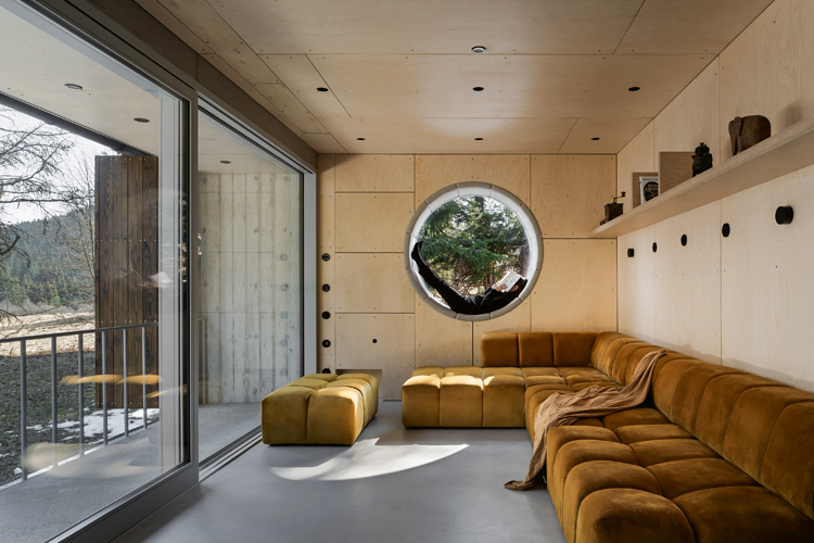 Wohnraum mit Holz und einem runden Fenster im Zentrum