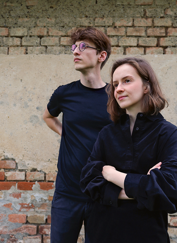 eine junge Frau und ein junger Mann vor einem alten Gemäuer