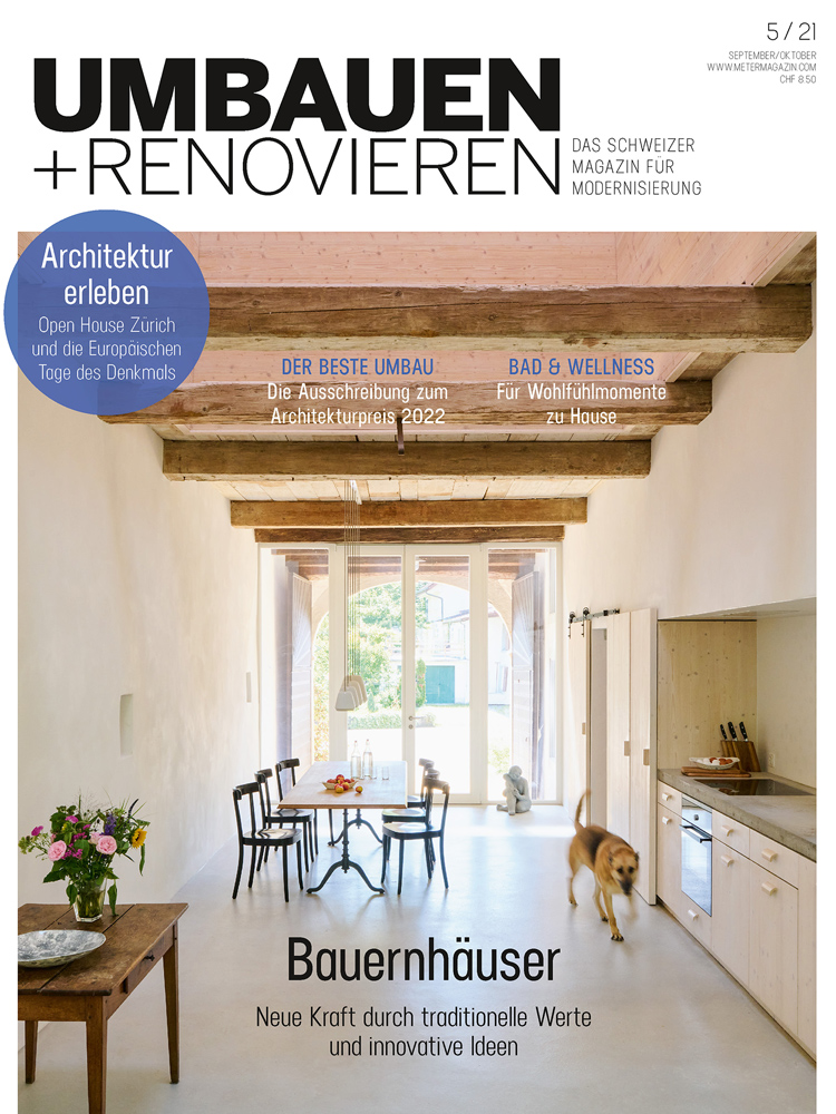 Titelbild der Zeitschrift Umbauen+Renovieren mit einer hölzernen Küche in einem hohen Raum mit Holzbalken