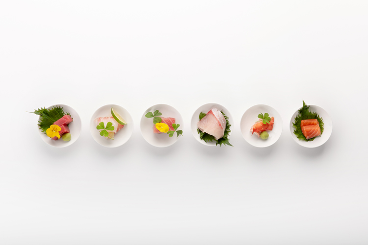 Aufnahme von sechs verschiedenen Sashimi von oben fotografiert in einer Reihe.