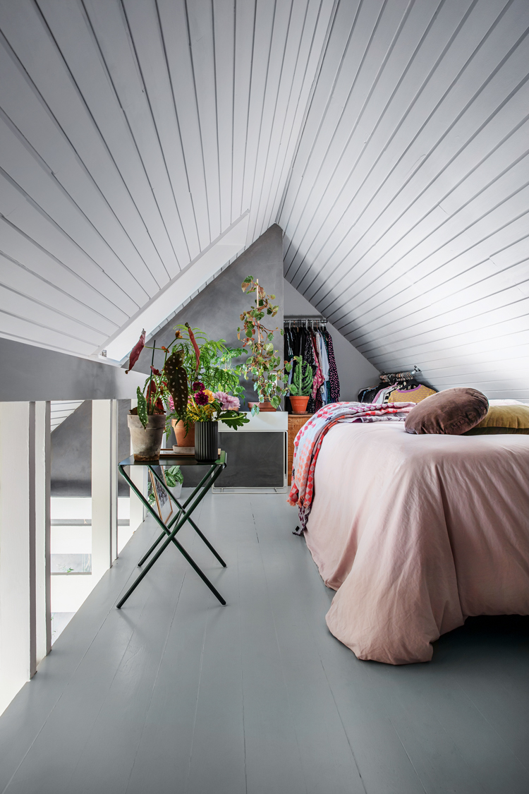 Schlafbereich unter Dachgiebel mit Dekopflanzen.