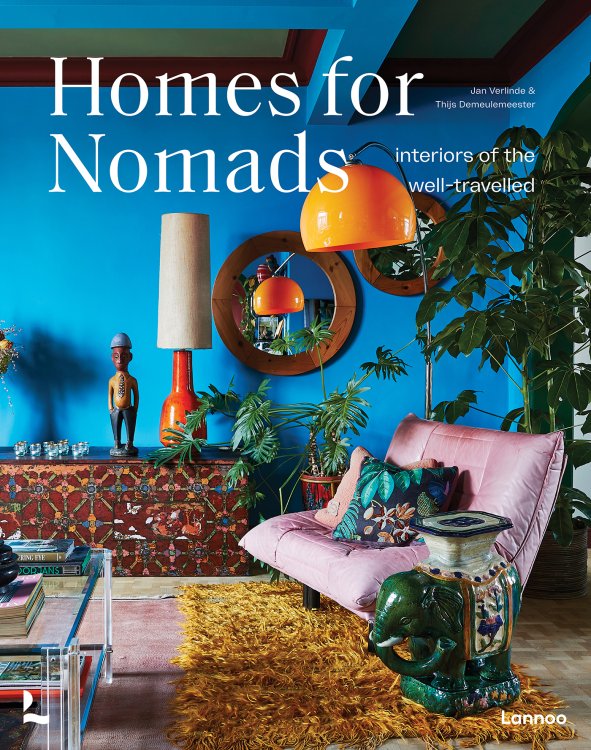 Coverbild des Buchs «Homes for Nomads» ein eklektisches Wohnzimmer mit türkis-blauer Wand, grossen Grünpflanzen und einem rosa Togo Einsitzer von Ligne Roset.