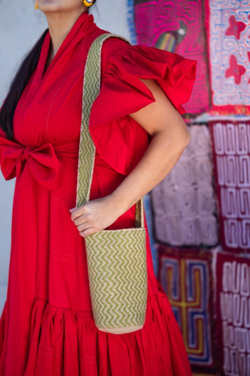 Frau mit rotem Kleid und handgemachter Glasperlentasche von Tauta.