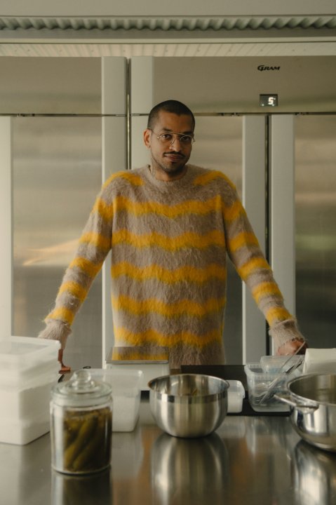 Food-Wissenschaftler David Zilber mit gelb-beigen Pulloverstehend vor Küchenzeile.