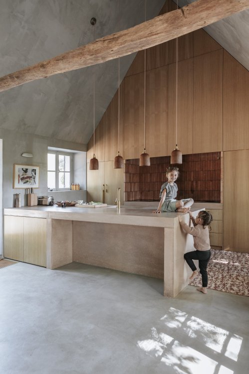 Moderne helle Küche mit Kochinsel und Giebeldach.