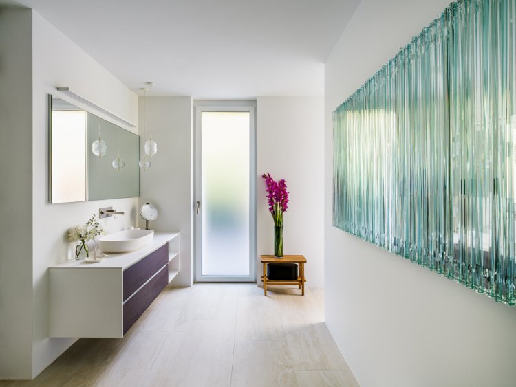 Badezimmer mit grossem türkisfarbenen Bild an der rechten Wand.