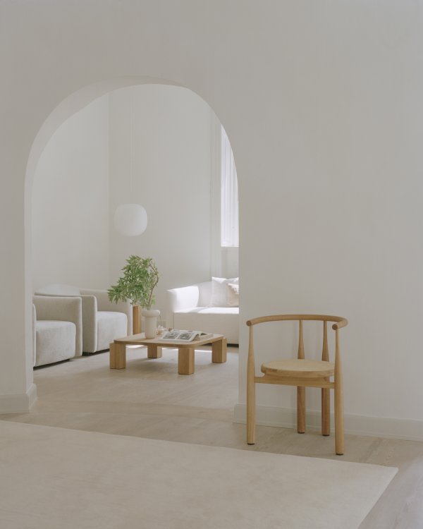 Ruhiges Interior in hellen Farben mit rundem Bogen, der in einen zweiten Raum führt.