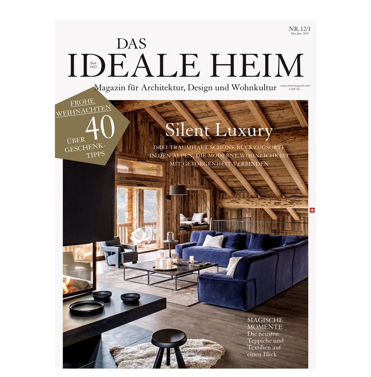 Cover der Zeitschrift Das Ideale Heim Nr. 12 von 2023 mit einer Aufnahme eines modernen Chalet-Wohnzimmer mit dunkel-blauem Sofa.
