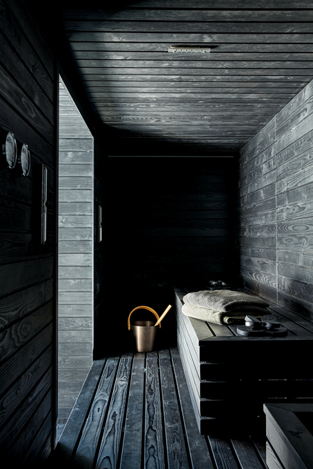 Sauna im Keller mit dunkler Holzverkleidung.