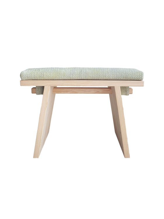 Seitenansicht einer freigestellten Sitzbank aus hellem Holz mit Wollkissen.