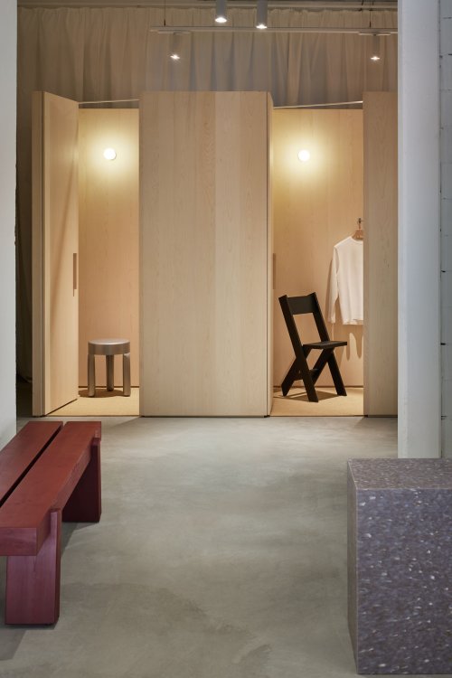 Umkleidebereich im Solané Store Zürich mit Möbeln aus hellem Holz, minimalistischer Beleuchtung und ruhiger Atmosphäre.