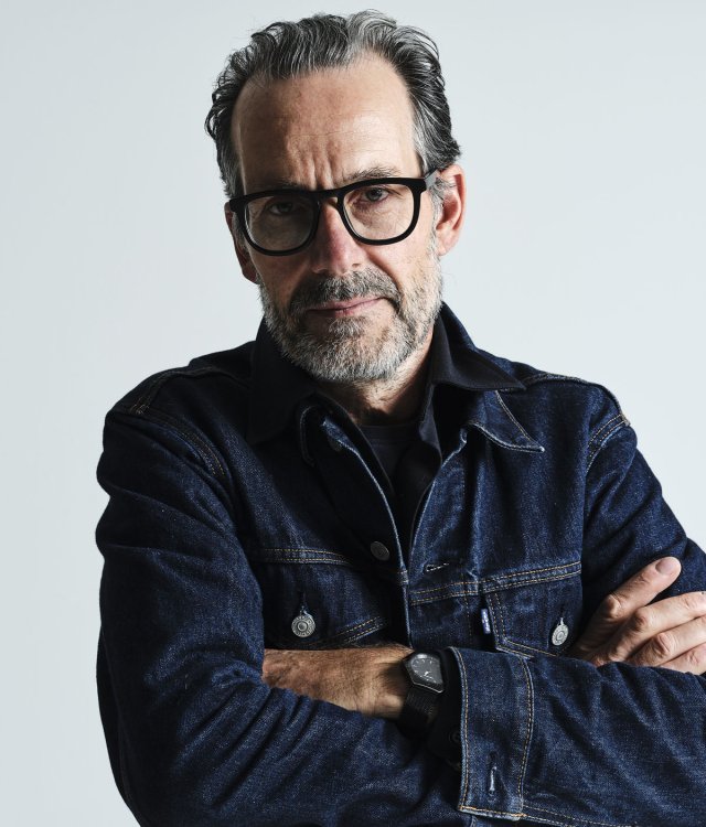 Porträt von Industriedesigner Konstantin Grcic mit verschränkten Armen vor hellem Hintergrund.