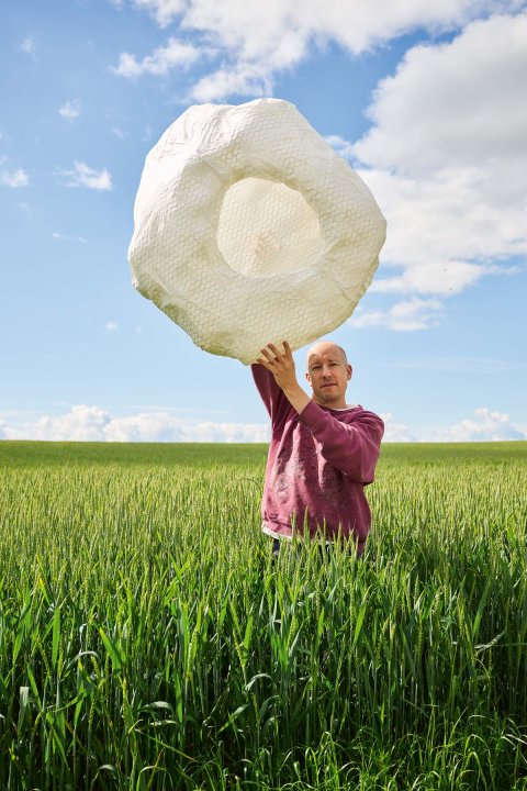Guy Meldem mit Papierobjekt in Kornfeld