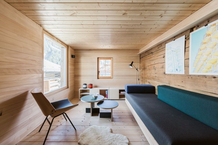 Wohnzimmer mit Holzwänden, Sofa und Sesseln