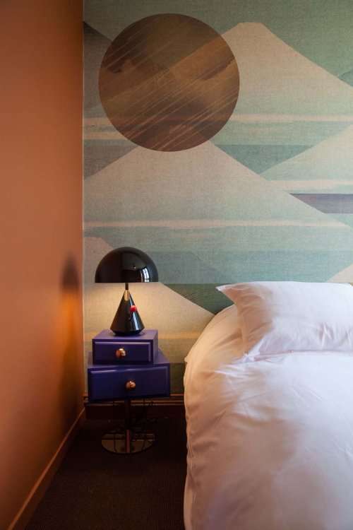 Bett mit Nachttisch bei gedämpftem Licht