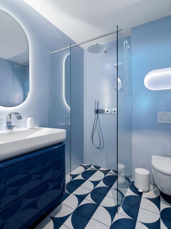 Badezimmer in Blautönen mit gemusterten Bodenfliesen