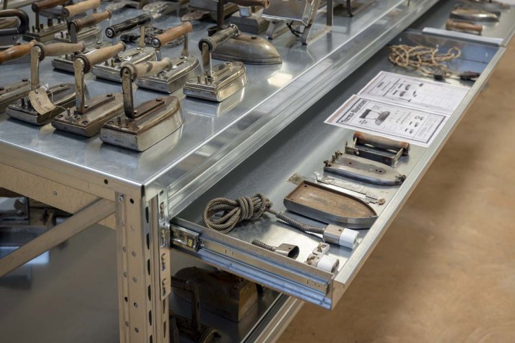 Werktisch mit historischen Bügeleisen