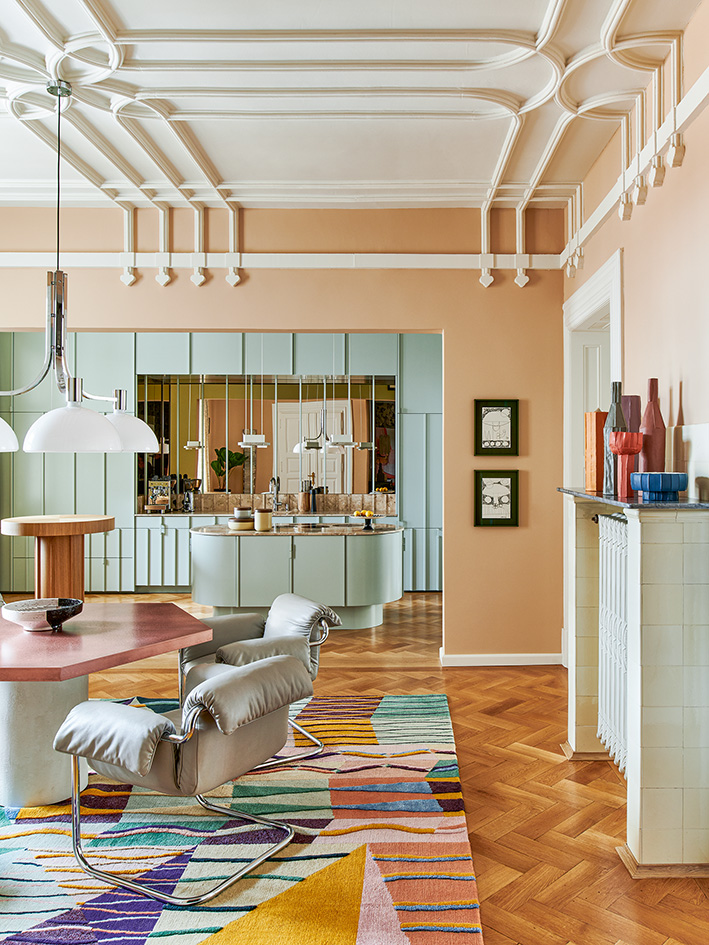 buntes Altbau-Wohnzimmer mit Küche im Hintergrund