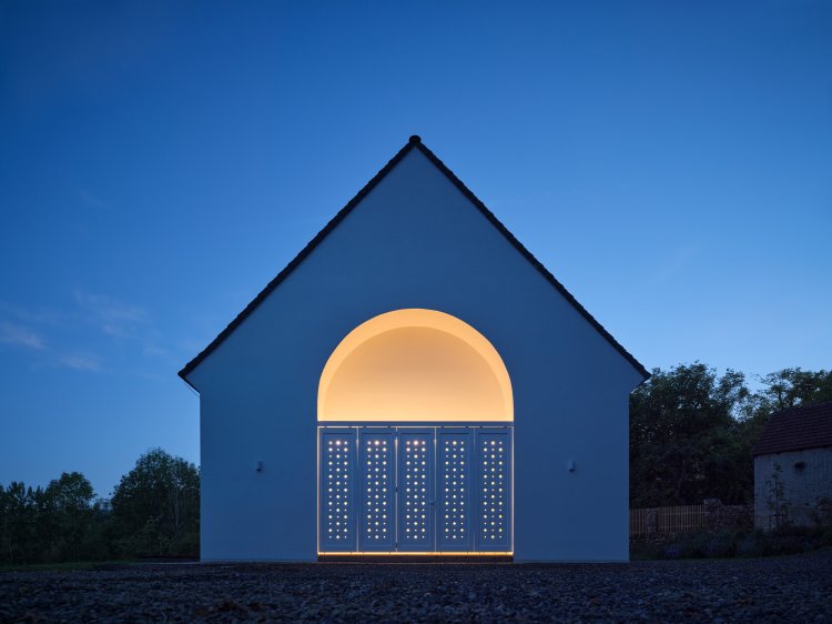 Blick auf das ganze Haus von aussen in der Dämmerung.