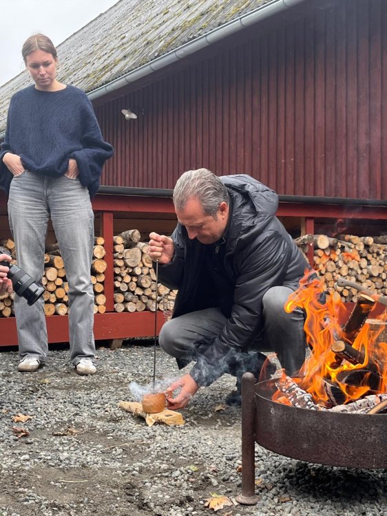 Designer Aurel Aebi brandmarkt seinen Holzbecher mit dem Electrolux-Logo.