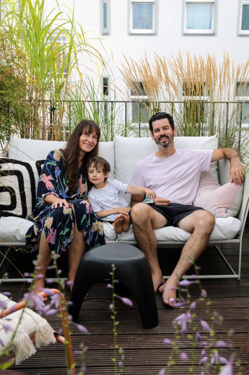 Julia mit ihrem Sohn und ihrem Mann auf einem Sofa auf der Terrasse