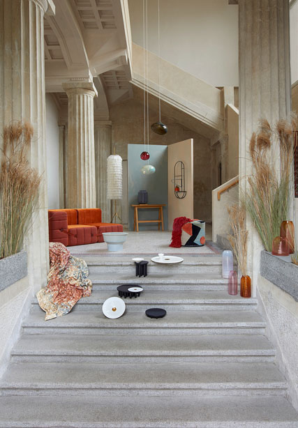 Blick auf eine Treppe di emit einzelnen Stücken, wie Teppiche, Vasen und anderen Sachen gestellt ist.