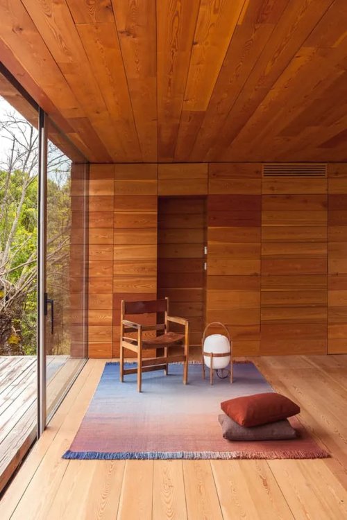 Ein Teppich liegt in einem Raum mit Holzboden und Wänden.