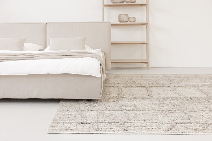 Bett mit unterlegtem Teppich