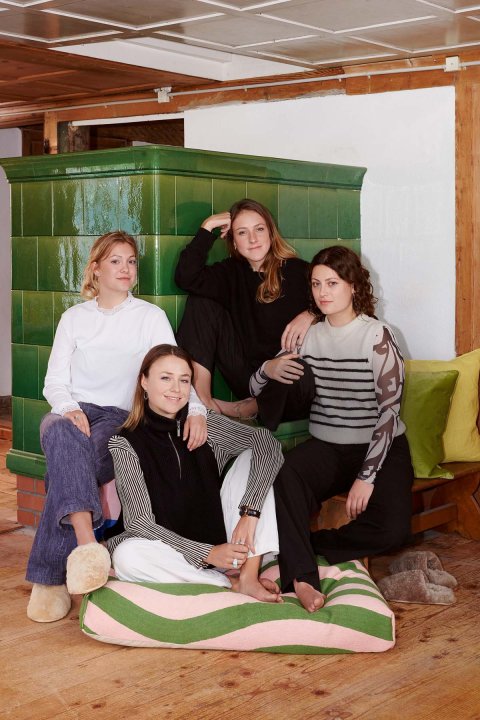 Vier Frauen die vor einer alten Heizung sitzen.