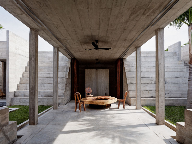 Überdeckter Aussensitzplatz mit Möbeln und Tisch aus Holz.