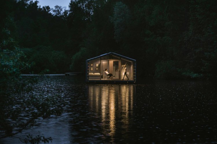 Das schwimmende Haus «DD16» von BIO Architects auf einem Fluss nahe Moskau, aufgenommen bei Nacht.