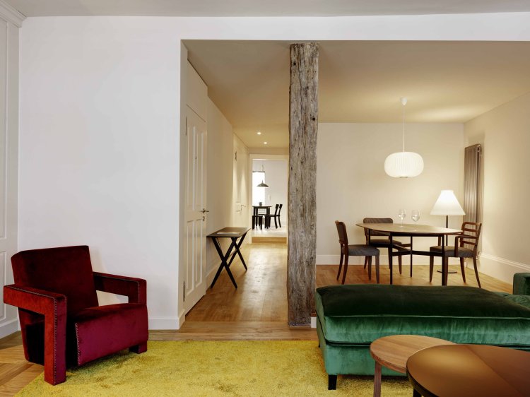 Wohnung des Widder-Hotels mit rot und grünem Polstermöbeln und modernem Umbau.